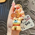 Cute Shiba Inu resin keychain with small bell and golden lobster clasp on dark background - Wood Carving Style Dog - Yellow