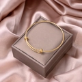 Detailed view of golden knot-style open bangle bracelet on luxury velvet packaging - Knot Adjustable Style (S235-8)