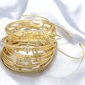Detailed view of stacked gold bracelets featuring shimmering cubic zirconia initial charms - Letter A / Gold
