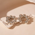 Dettaglio di ear cuff argentati a sfere metalliche a forma di C su base neutra - Ear cuff - Argento
