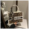 Détail du sac cabas léopard avec bordure blanche et foulard en soie sur la poignée - Kaki