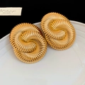 Makro-Detail goldener geometrischer Doppelspiral-Ohrringe mit strukturierter Oberfläche - S925 Silber Nadel Stil / Gold