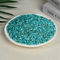 Natural turquoise crystal chips in a white dish, vibrant blue stones with brown textures - 100 Grams Of Artificial Turquoise (3-5mm)