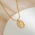 Primer plano de collar dorado con colgante letra B y marco ovalado de circonitas - Letra B
