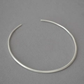 Detailopname van een zilveren minimalistische open choker ketting op grijze achtergrond - Antiek Zilver