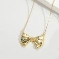 Gros plan du pendentif nœud plaqué or avec finition texturée et gemmes multicolores - Nœud