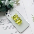 Primo piano del supporto per telefono a forma di orso giallo traslucido su iPhone - Supporto Orso / Giallo ocra