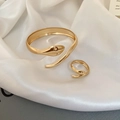 Macro shot of gold snake-shaped open bracelet and ring set on white silk fabric - Snake Shape Set / Gold