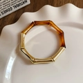 Detail of gold bamboo-shaped bracelet with amber resin segments in a ceramic dish - 16# Bracelet-Amber Brown Bamboo
