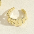 Detailed close-up of a golden wave-shaped adjustable ring with a polished fluid design - Woven Metal Ring