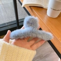 Light blue faux fur shark hair claw clip for women shown in a cozy lifestyle setting - Light Blue Plush Hair Claw