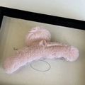 Close-up of light pink plush shark hair clip with soft pom-pom detail in a display tray - Light Pink