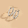 Macro detail of silver hoop earrings featuring baguette-cut zircon in a channel setting - Double-sided Zirconia (Silver)