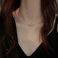 Collana choker di perle d'acqua dolce con ciondolo a cuore dorato su una modella - Argento 925 / Perla Artificiale 3mm Con Cuore
