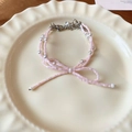 Gros plan du collier nœud perlé rose avec perles d'imitation sur assiette décorative - Bracelet Nœud Rose