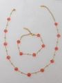 Detail of bohemian gold stainless steel jewelry set with pink beaded floral designs - Orange Necklace And Bracelet