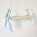Detail of wooden wall shelf with light blue beads and decorative tassels in Nordic style - Light Blue