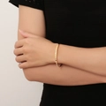 Gepolijste gouden zirkoon armband met vierkante schakels gedragen om de vrouwenpols - B074 Goud