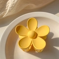 Close-up of yellow flower hair claw clip with matte finish on white ceramic plate - Leaf Yellow