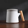 Matte beige ceramic mug with elegant wooden handle and matching lid on a dark table - Milky White