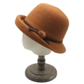 Detail of warm knit cloche hat with brown ribbon bow and soft faux fur ball accent - M (56-58cm) / Caramel color