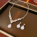 Macro shot of silver teardrop zircon necklace and earrings set on a display tray - Silver