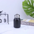 Close-up of mini black stainless steel thermal cup on a marble table with decor - 300ml / Black