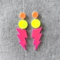Detail der Neon-Acryl-Ohrringe mit fluoreszierenden geometrischen Blitz-Anhängern - Rosenroter Blitz