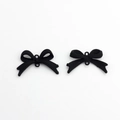 Macro detail of matte black alloy bow connectors with fine stitched texture for DIY crafts - Black