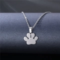 Minimalist silver dog paw print necklace with hollow pendant on a gray display stand - Paw