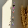 Detail of crystal sun catcher with moon and star metal accents reflecting rainbow light - Star Crescent Moon Sun