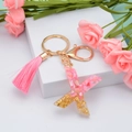 Pink resin letter X keychain with gold ring, decorative tassel and gold leaf flakes - Letter X