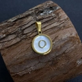 Gold round natural shell pendant featuring letter O on a rustic wood texture - Letter O / 17x20mm