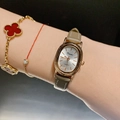 Women's gold quartz watch with oval dial and khaki leather strap on model wrist - Leather Strap / Rose Gold Case/Grey Strap