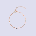 Detail of gold-plated lip chain with orange enamel charms and adjustable lobster clasp - Gold + Orange