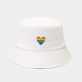 Dettaglio del ricamo a cuore arcobaleno su un cappello a secchiello in cotone bianco - M (56-58cm) / Bianco