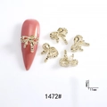 Detail of 11x10mm gold bow nail charms with rhinestones on pink almond fake nails - 1472# Gold Rhinestone Bowknot