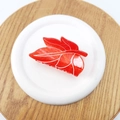 Detailed view of leaf-shaped red acetate hair claw clip with white marble vein patterns - 8cm / Orange