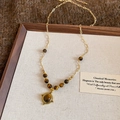 Detailed view of vintage gold tiger eye stone pendant on a delicate chain necklace - 50# Gold Coffee Round Necklace