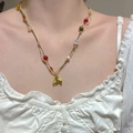Bunte Perlenkette im Boho-Stil mit goldenem Pferdepfosten-Anhänger am Modell - Goldimitat Bunte Perlenstil