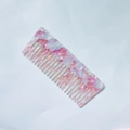 Vista dettagliata della trama marmorizzata rosa e bianca sul pettine in acetato - Viola Chiaro