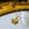 Elegant gold bow pendant necklace on mirror surface with vintage frame background - Gold