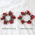 Vue détaillée de couronnes de baies de Noël avec pommes de pin vraies et fausses - Pommes de pin naturelles / Baies givrées rouges avec pommes de pin naturelles
