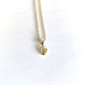 Macro detail of polished gold letter U pendant necklace with a delicate chain - Letter U