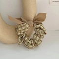 Khaki plaid scrunchie with solid ribbon bow on a ceramic display stand for women - Khaki Plaid Bow