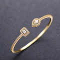 Macro detail of gold-plated brass cuff bracelet featuring drop and rectangle zircon stones - Gold with White Zircon