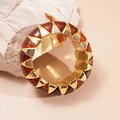 Macro shot of geometric amber acrylic and gold metal elastic bracelet on a textured stone - Dark Coffee