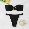 Detalle de bikini bandeau negro con aro de metal dorado sobre fondo de mármol elegante - S / Negro