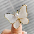Vintage enamel butterfly brooch with white pearl and gold finish on fingertips - Classic Butterfly Brooch