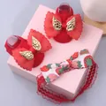 Detail of red baby socks and strawberry print headband set with lace bow and gold charm - Style 5 (Red Wings/Red Strawberry)